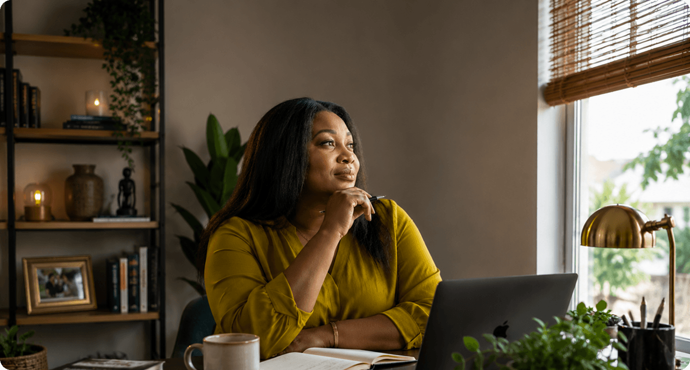 Woman reflecting beside an office window