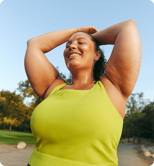 Woman smiling outdoors in a yellow top